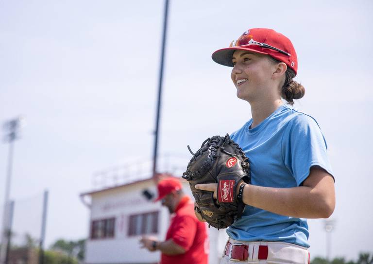 Meredith McFadden laughs during warm-ups at baseball practice at Olympic High School in Charlotte, N.C., on Tuesday, May 25, 2021. KHADEJEH NIKOUYEH KNIKOUYEH@CHARLOTTEOBSERVER.COM