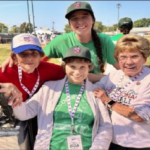 Sara Rose Thibaut stands for a picture with three women who played professional baseball in the 1940s, Jeneane Lesko, Sue Zipay and Gloria Rogers.